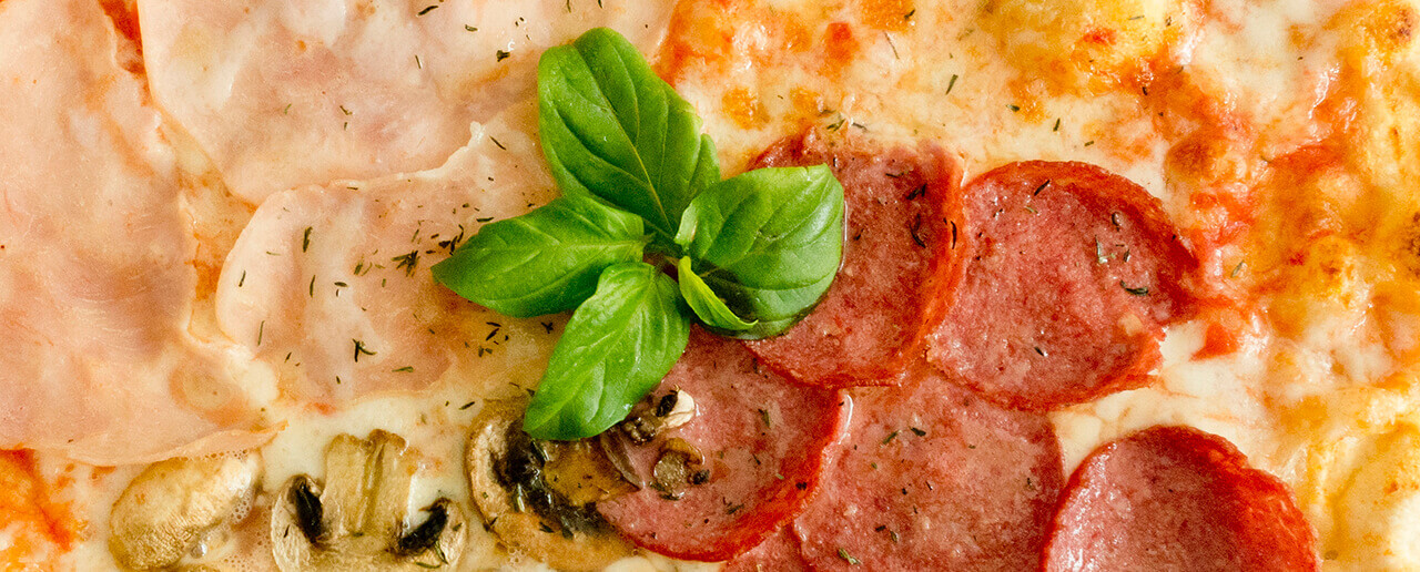 pizza close up with cheese, beef salami, herbs and fresh basil. Close up